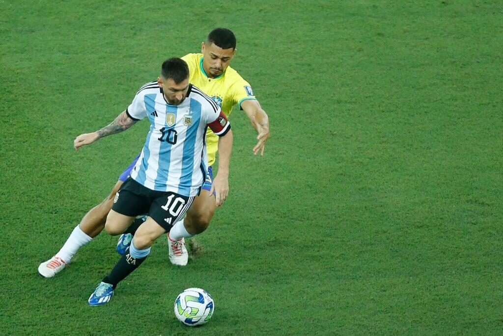 Andre Trindade của Brazil (R) đuổi theo Lionel Messi của Argentina (L) trong trận đấu vòng loại FIFA World Cup 2026 giữa Brazil và Argentina tại Maraca...